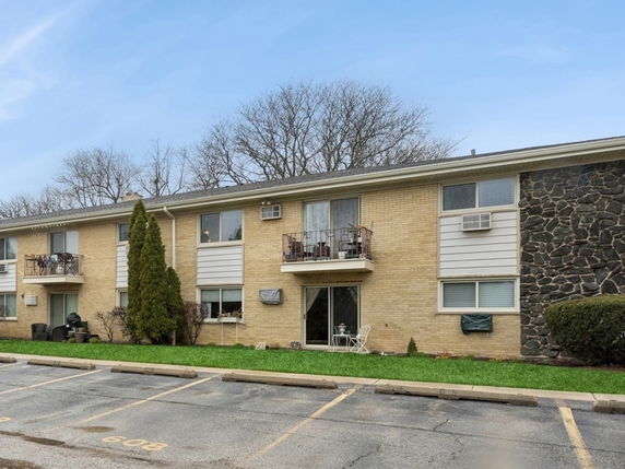 Front view of a two-story apartment building with balconies.