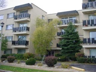 Front view of a multi-story apartment building with balconies.