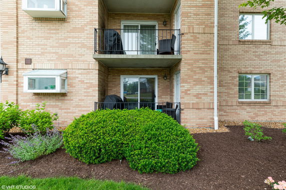 Front view of a brick building with balconies and windows.