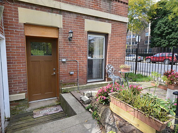 Front view of a brick building with a door and window visible.