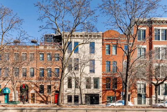 Front view of multi-story brick buildings with large windows.