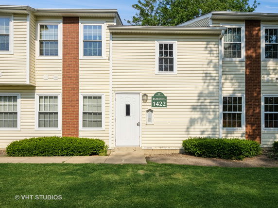 Front view of a two-story building with a combination of brick and siding exterior and multiple windows.