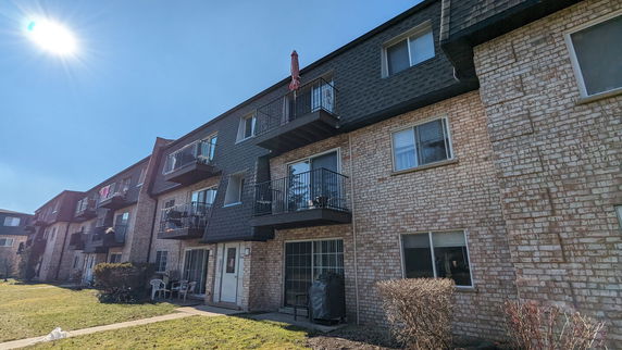 Front view of a multi-story residential building with balconies.