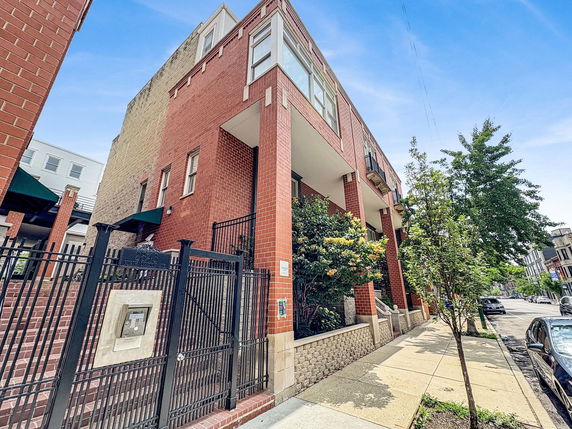 Front view of a brick residential building with gated entry.