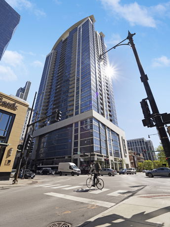 Front view of a tall modern residential building on a city street.