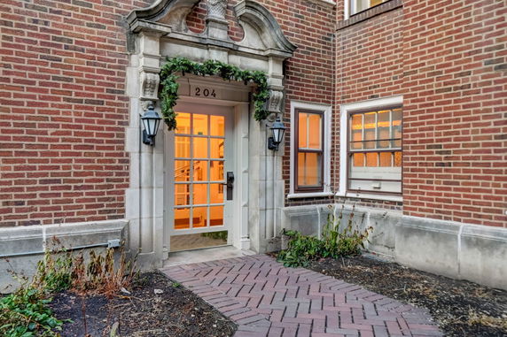 Front view of a building entrance with decorative trim and glass door.