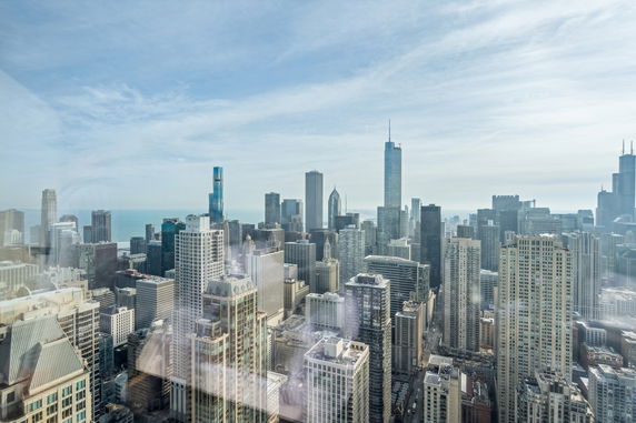 Panoramic view of a city skyline with skyscrapers and a waterfront in the background.