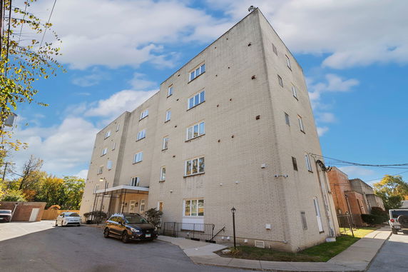 Front view of a multi-story apartment building with a brick exterior.