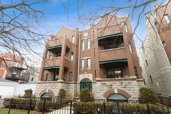 Front view of a multi-story brick building with balconies.
