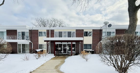 Front view of a two-story building with red brick and white accents.