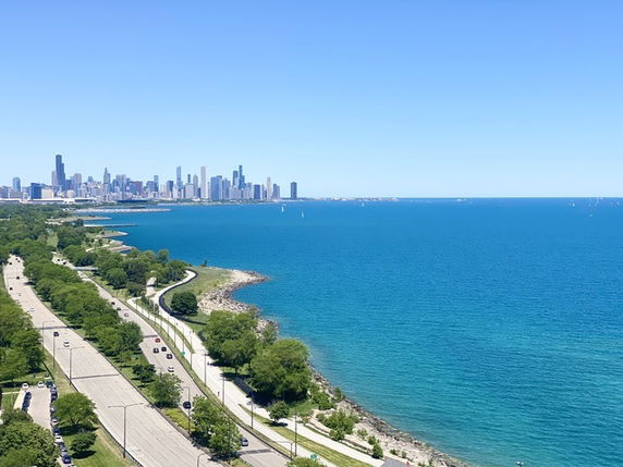 Panoramic view of a city skyline and a large body of water.