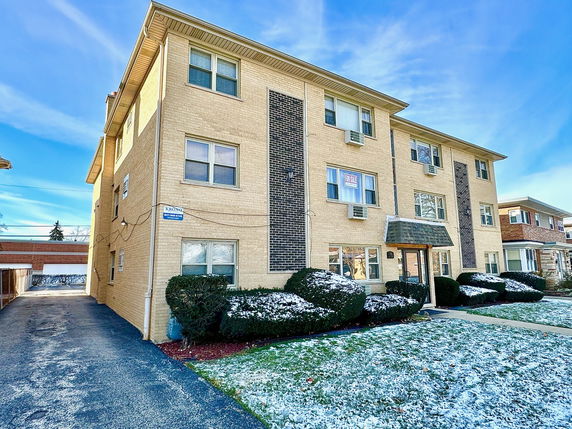 Front view of a multi-story apartment building with brick exterior.