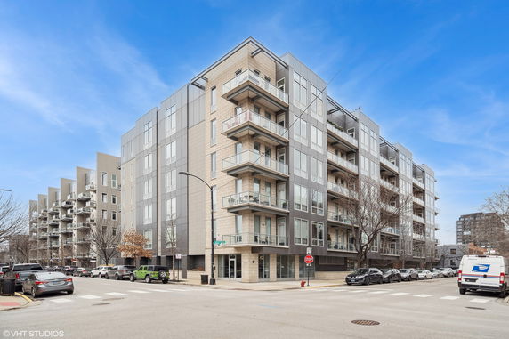 Front view of a modern multi-story apartment building with balconies.
