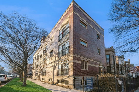 Front view of a multi-story residential building with a brick facade.