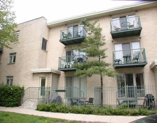 Front view of a multi-story apartment building with balconies.