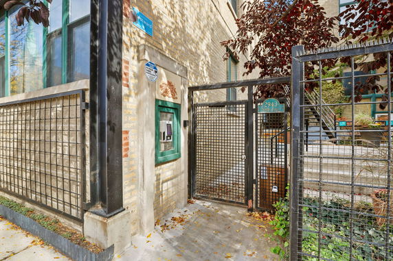 Entrance view of a building with a gated entry and brick exterior.