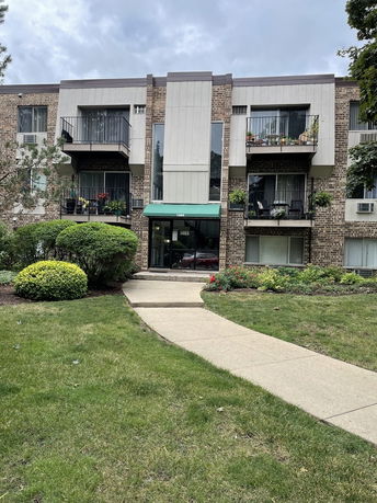Front view of a multi-story apartment building with balconies.