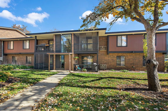 Front view of a two-story brick apartment building with balconies.