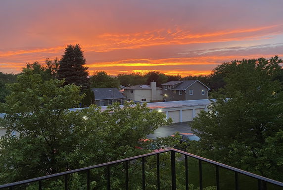 Panoramic view of surrounding area with houses and trees at sunset.