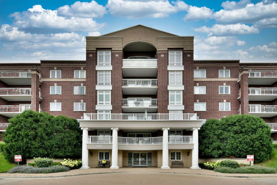 Front view of a multi-story building with balconies and large entrance.
