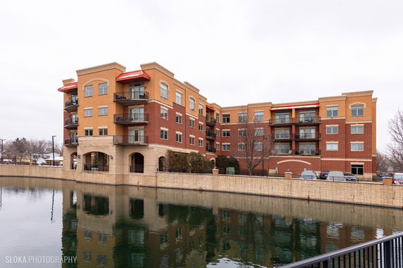 Front view of a multi-story apartment building with brick and stone facade.