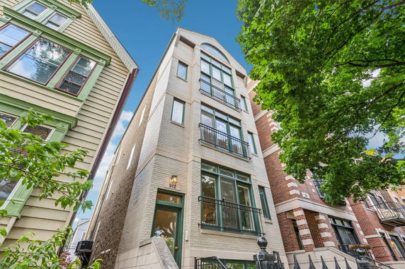 Front view of a multi-story residential building with large windows and balconies.