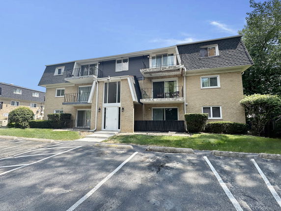 Front view of a three-story apartment building with balconies.