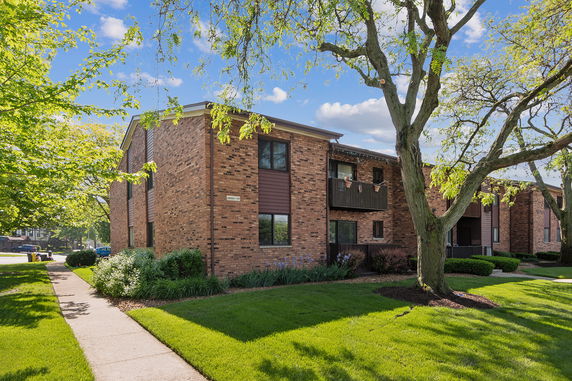 Front view of a brick apartment building with balconies.