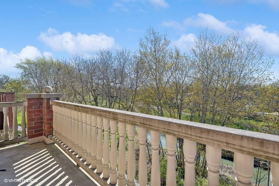 Panoramic view from a balcony overlooking trees and a river.