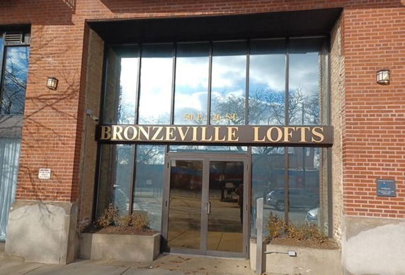 Front view of a loft building with large glass windows and brick facade.