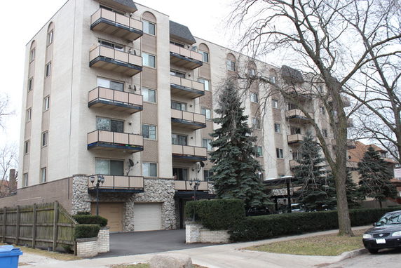 Front view of a multi-story apartment building with balconies.
