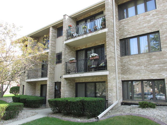 Front view of a multi-story apartment building with balconies.