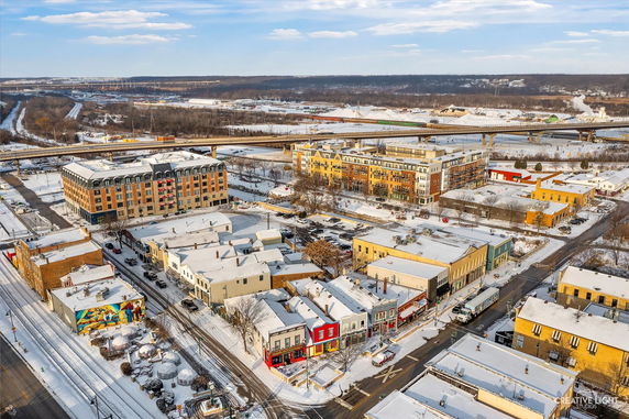 Aerial view of a town with snowy rooftops and surrounding landscape.