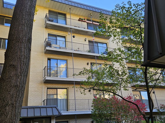 Front view of a multi-story apartment building with balconies.