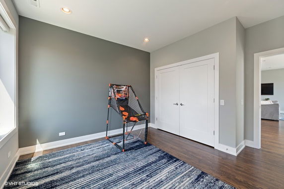 Room with a basketball arcade game and closed double doors.