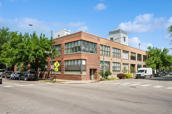 Front view of a two-story brick building on a street corner.