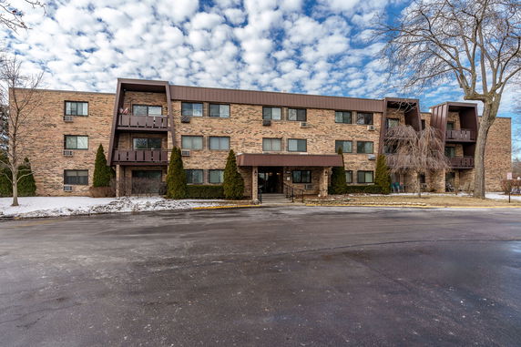 Front view of a multi-story brick apartment building.