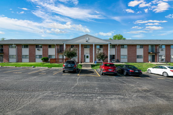 Front view of a two-story apartment building with parking area.