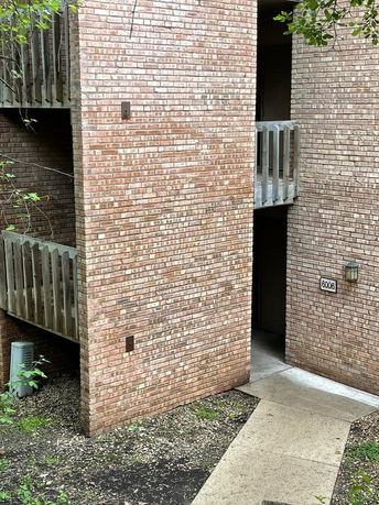 Exterior view of a brick building with balconies.