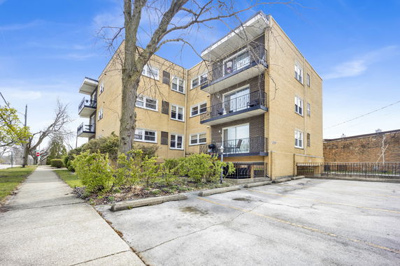 Front view of a multi-story apartment building with balconies.