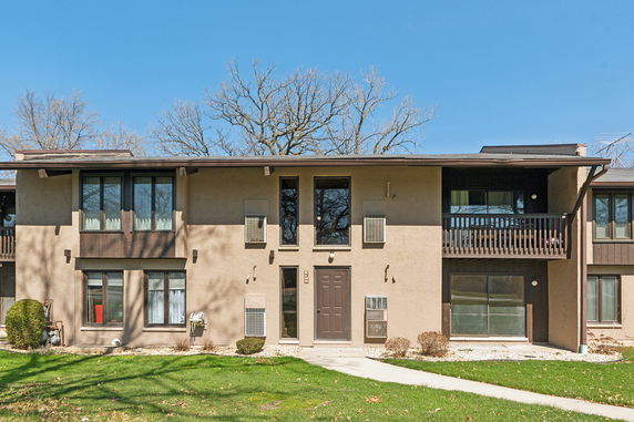 Front view of a two-story apartment building with balconies and a central entrance.