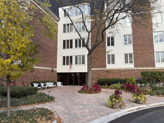 Front view of a multi-story brick building with a paved entrance area.