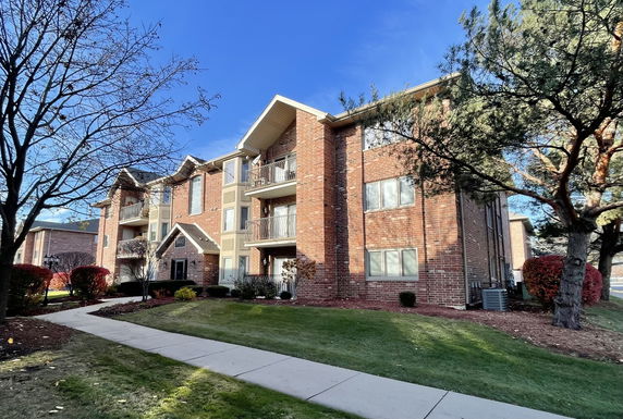 Front view of a multi-story brick apartment building.