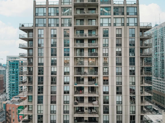 Front view of a high-rise residential building with multiple balconies.