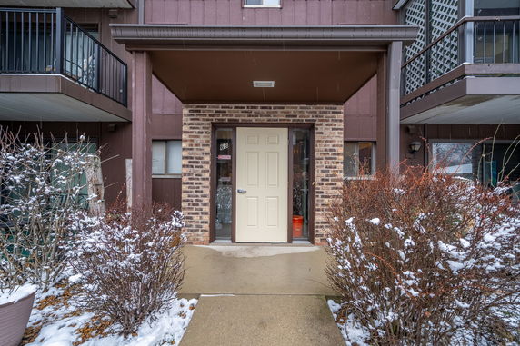 Front view of a building entrance with a covered doorway and brick facade.