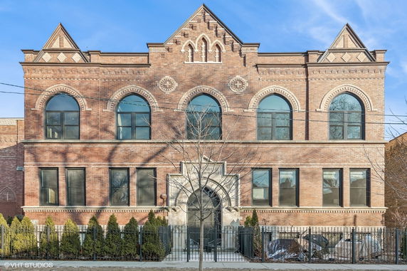 Front view of a historic-style brick building with ornate arches and windows.