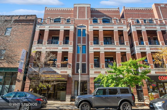 Front view of multi-story brick building with multiple balconies.