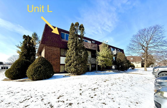 Front view of a multi-story brick building with snow on the ground.