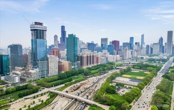 Panoramic view of a city skyline with tall buildings and a park area.