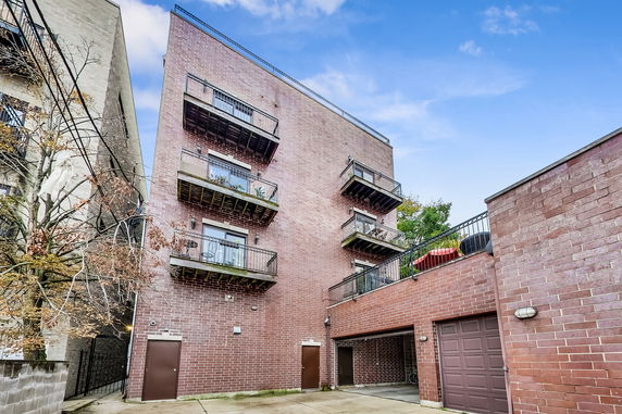 Side view of a multi-story brick building with multiple balconies.